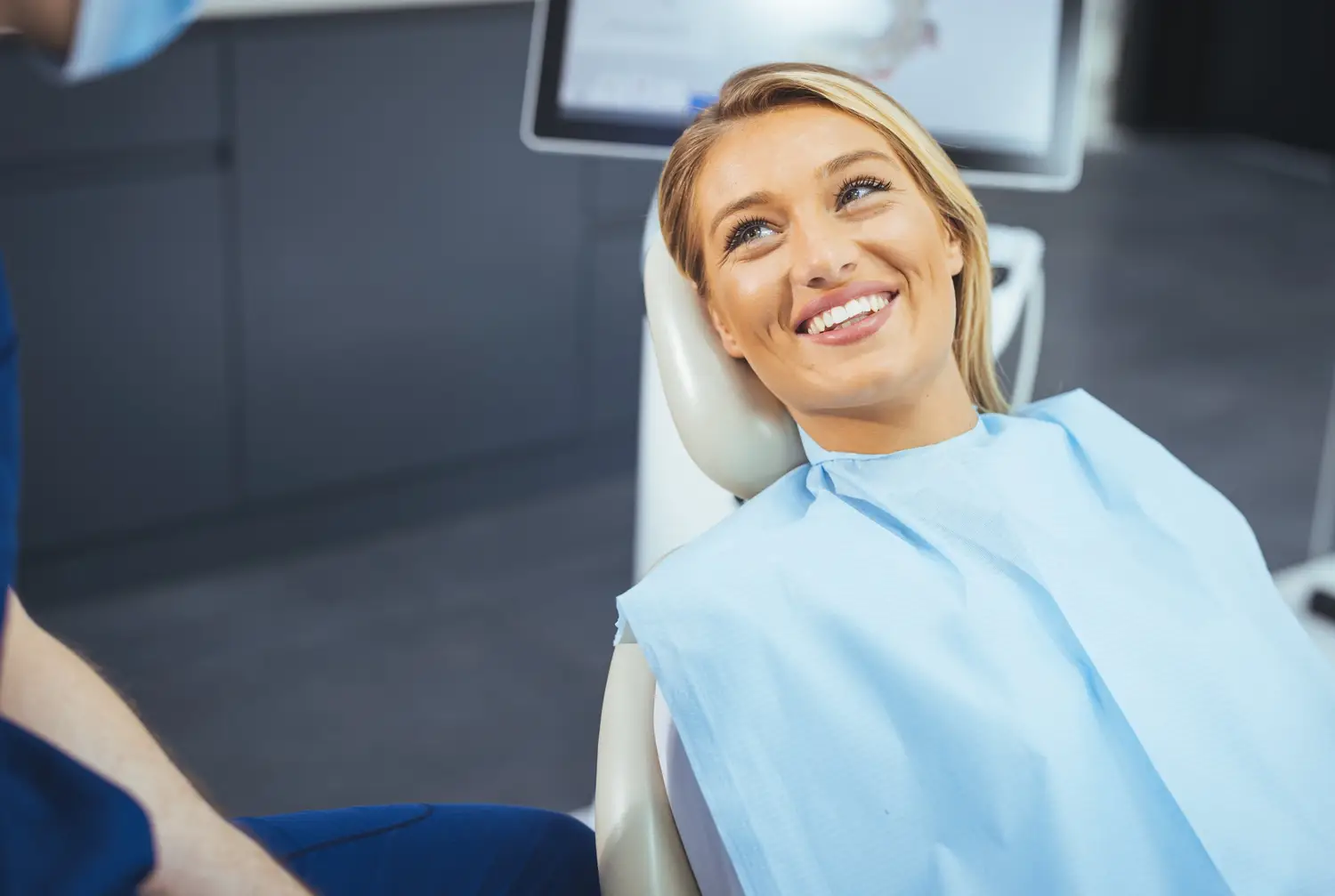 Patient relaxing in the dental chair while talking with the orthodontist