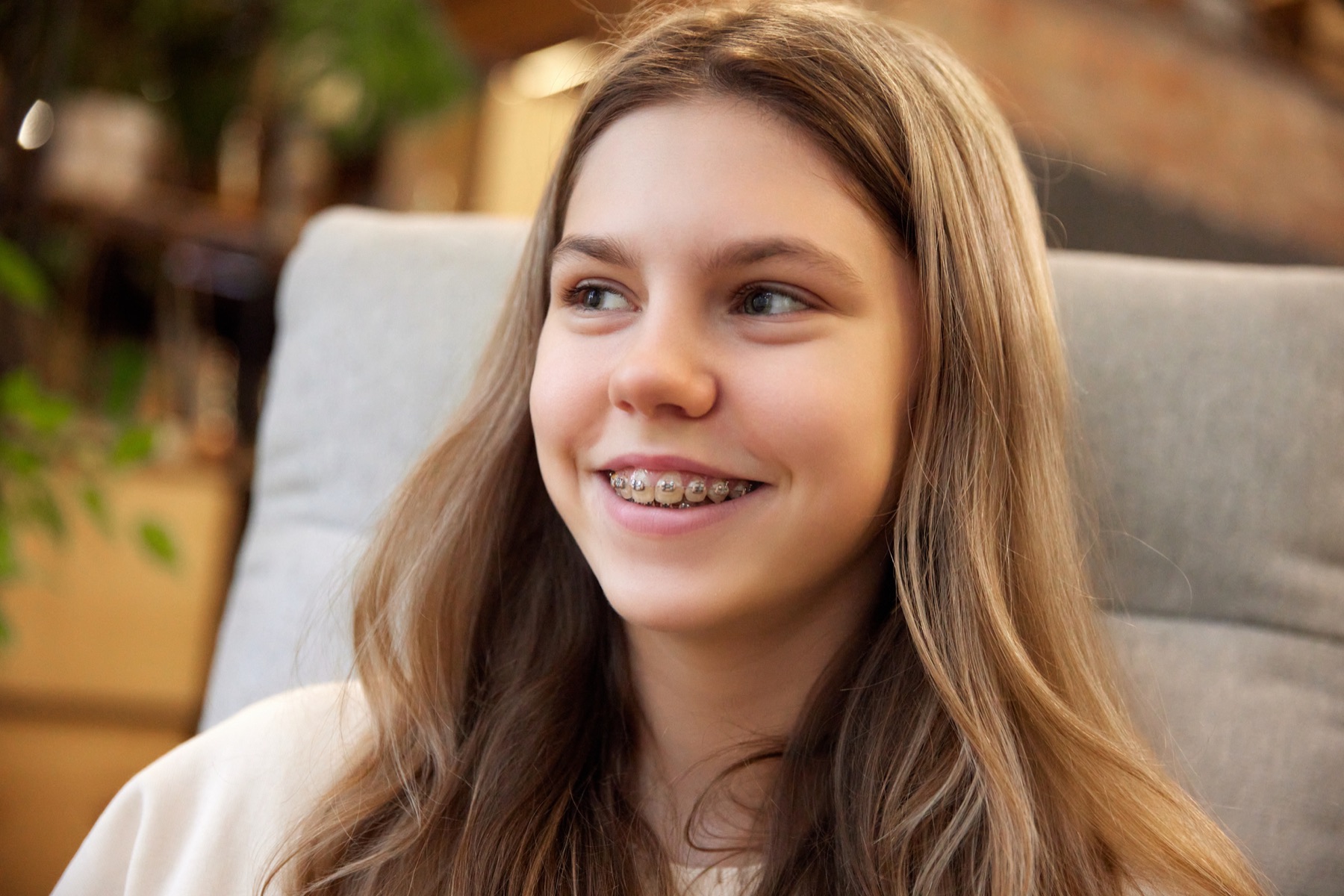 Close view of a young woman's smile with clear brackets